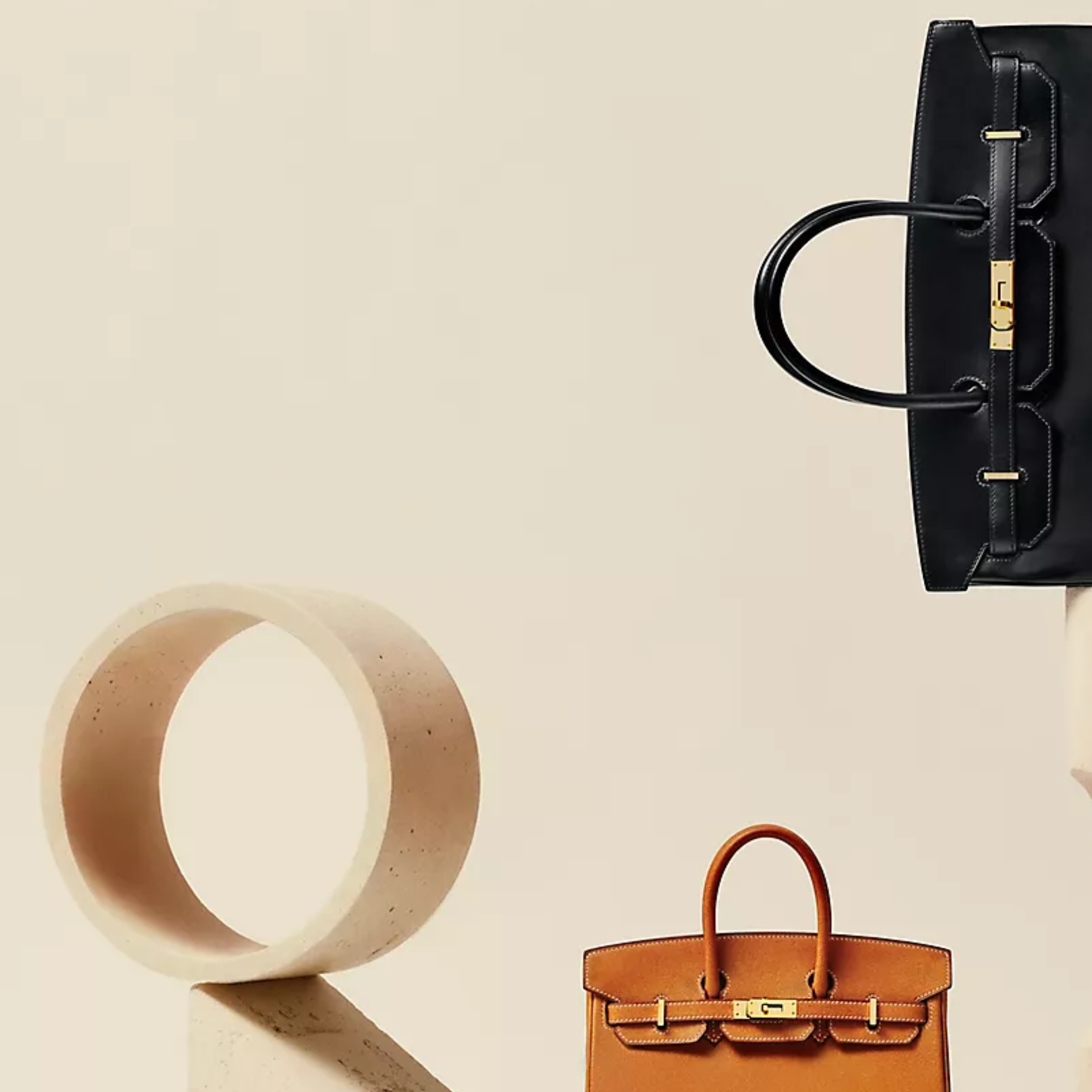 Hermès Birkin and Haut à Courroies handbags displayed in a minimalist studio setting.