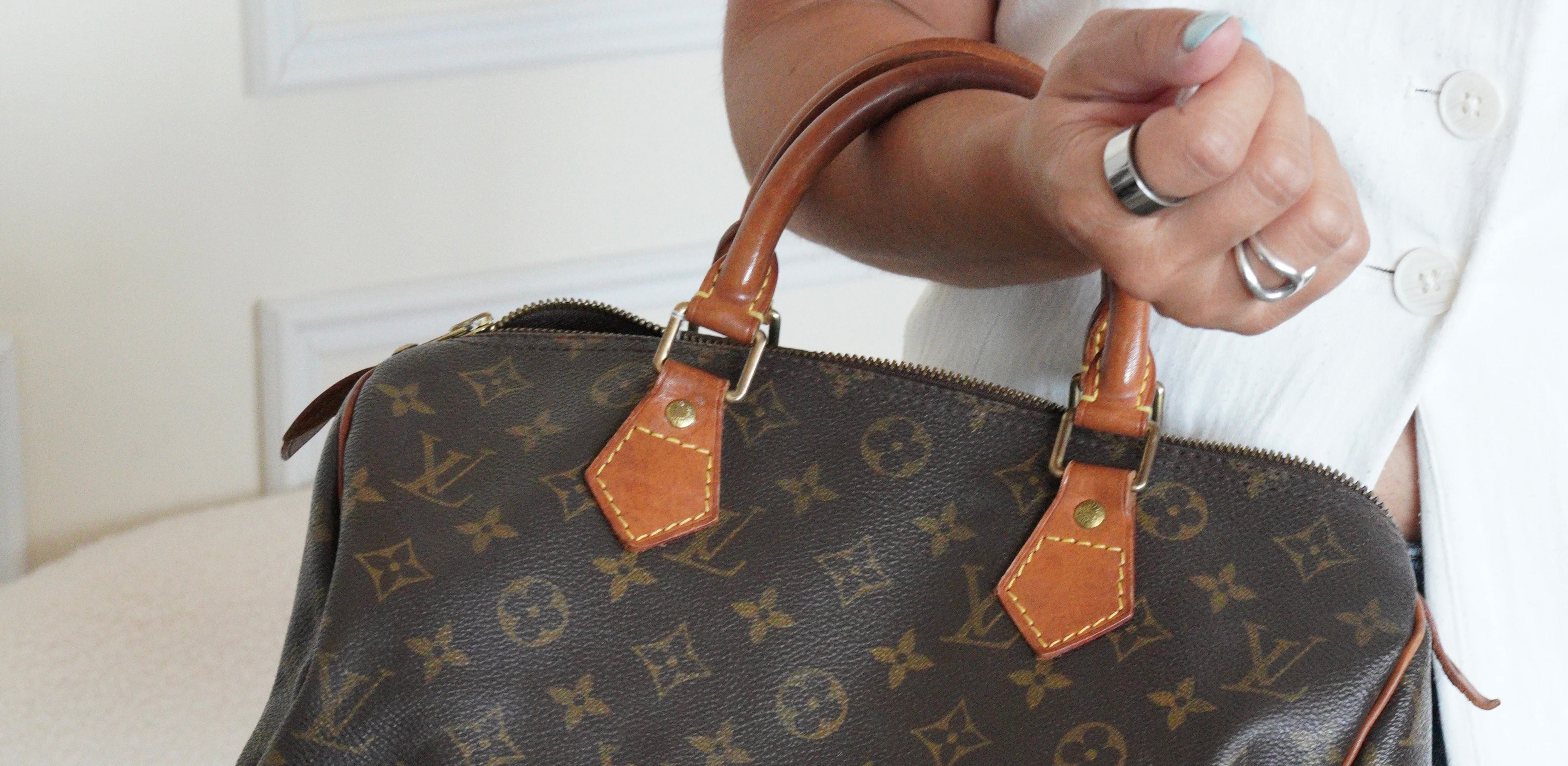 Vintage Louis Vuitton Speedy Monogram handbag showing natural leather patina on the handles.